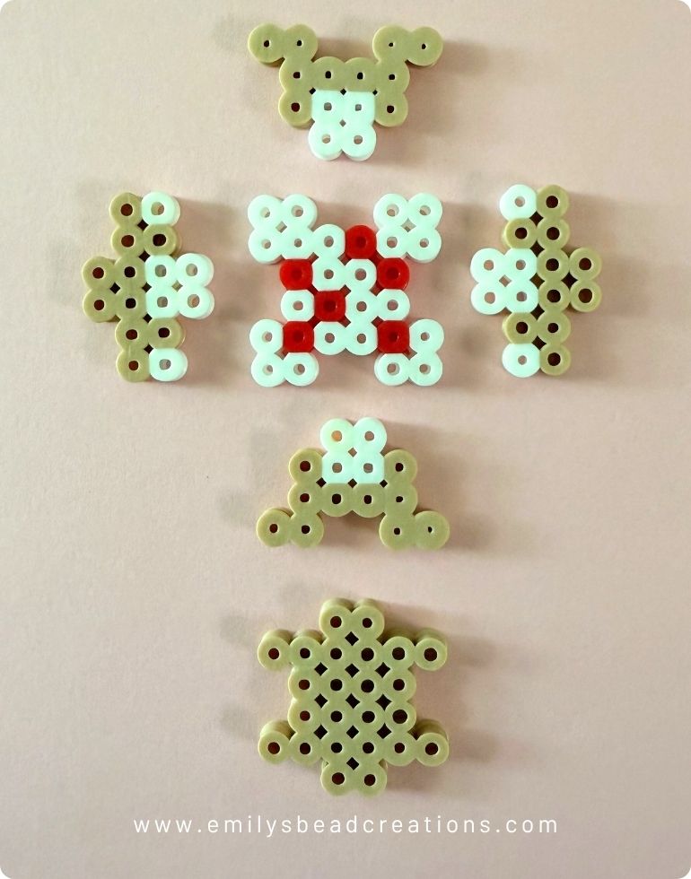 6 pieces of fused Perler beads arranged to show the Minecraft Cake 3D pattern.