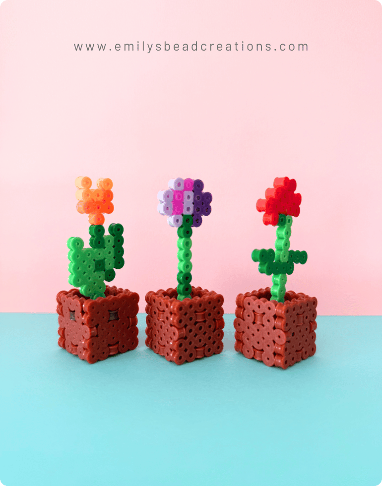 A photo of 3 minecraft perler flower pots with a blue and pink background.